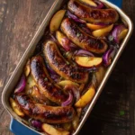 Caramelized sausages cooked with apples and red onions on a plate