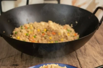 Plate of easy chicken fried rice garnished with green onions and vegetables.