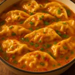 Delicious baked potstickers with Thai curry sauce served on a plate.