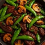 Beef stir-fry with snow peas and mushrooms in a vibrant dish