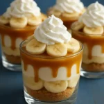 Delicious caramel banana pudding cups topped with whipped cream and banana slices.