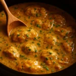 Crockpot Chicken and Gravy served in a bowl with mashed potatoes and herbs