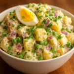 Delicious bowl of creamy potato salad garnished with fresh herbs