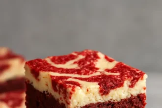 Decadent Red Velvet Cream Cheese Brownies topped with creamy frosting.