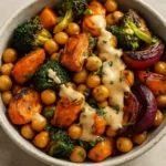 Roasted veggie and chickpea bowl drizzled with maple dijon tahini dressing