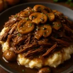 Slow cooker beef roast with mushrooms and onion gravy on a plate